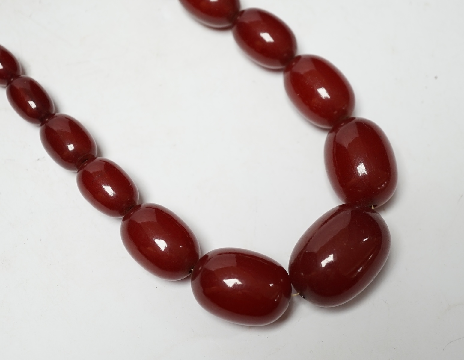 Two single strand simulated cherry amber necklaces, longest 42cm, gross weight 127 grams. Condition - fair